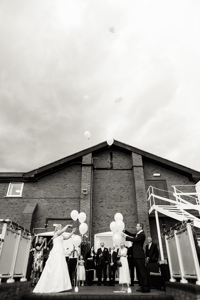 Bride and groom releasing balloons