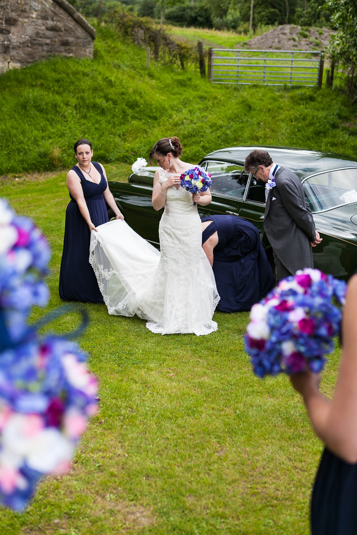 Bride getting out of wedding car