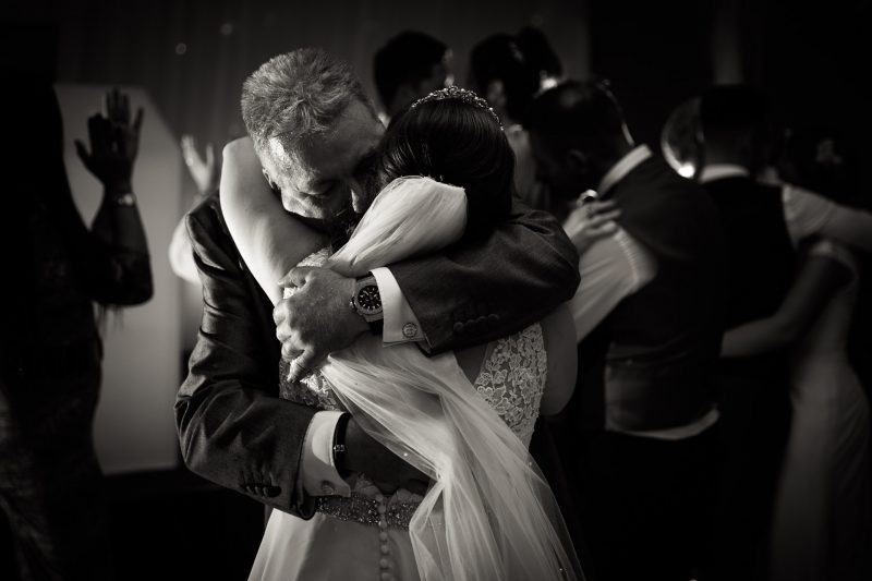 Bride and Father hug at evening reception