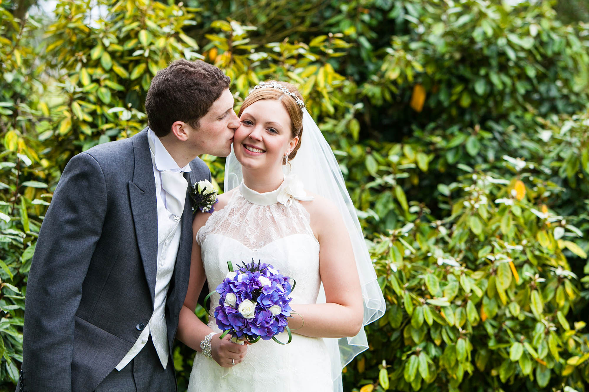 groom kissing bride in the gardens at the oriel hotel