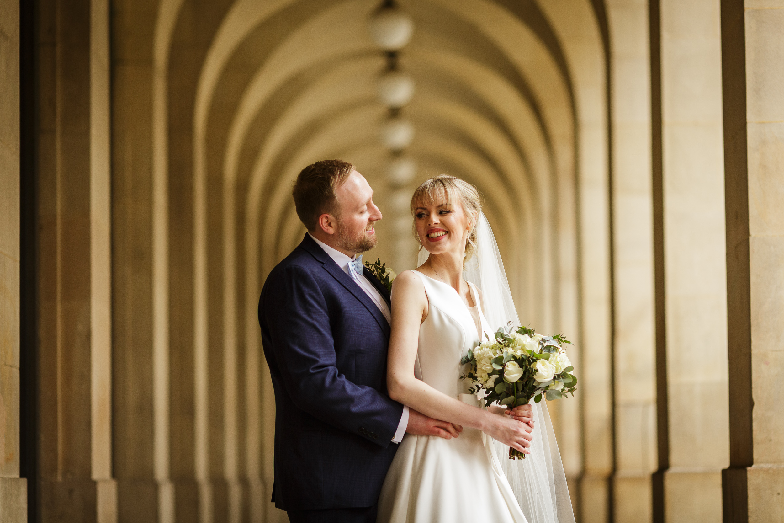 bride and groom posing in arches