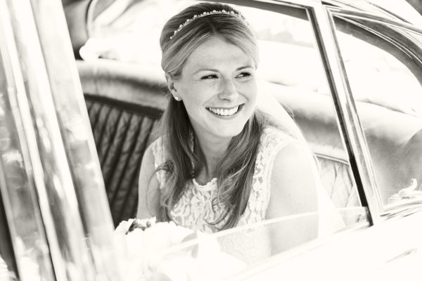 bride smiling in wedding car