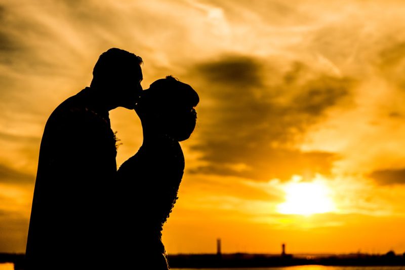 bride and groom kissing at sunset liverpool docks