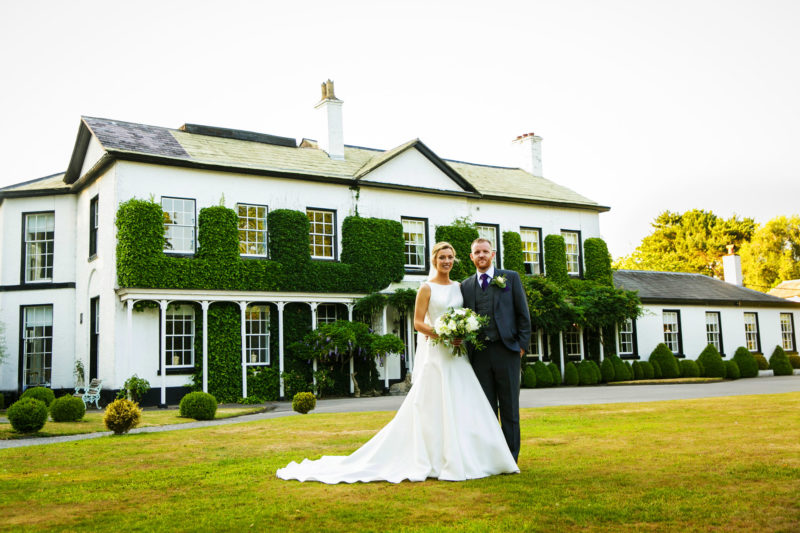 Bride and groom in front of Statham Lodge wedding