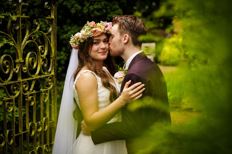 groom kissing bride on cheek at abbeywood estate