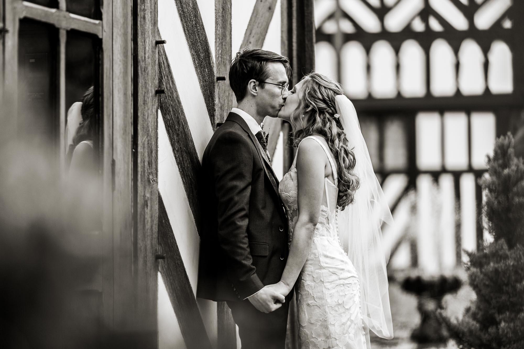 black and white photo of bride and groom kissing