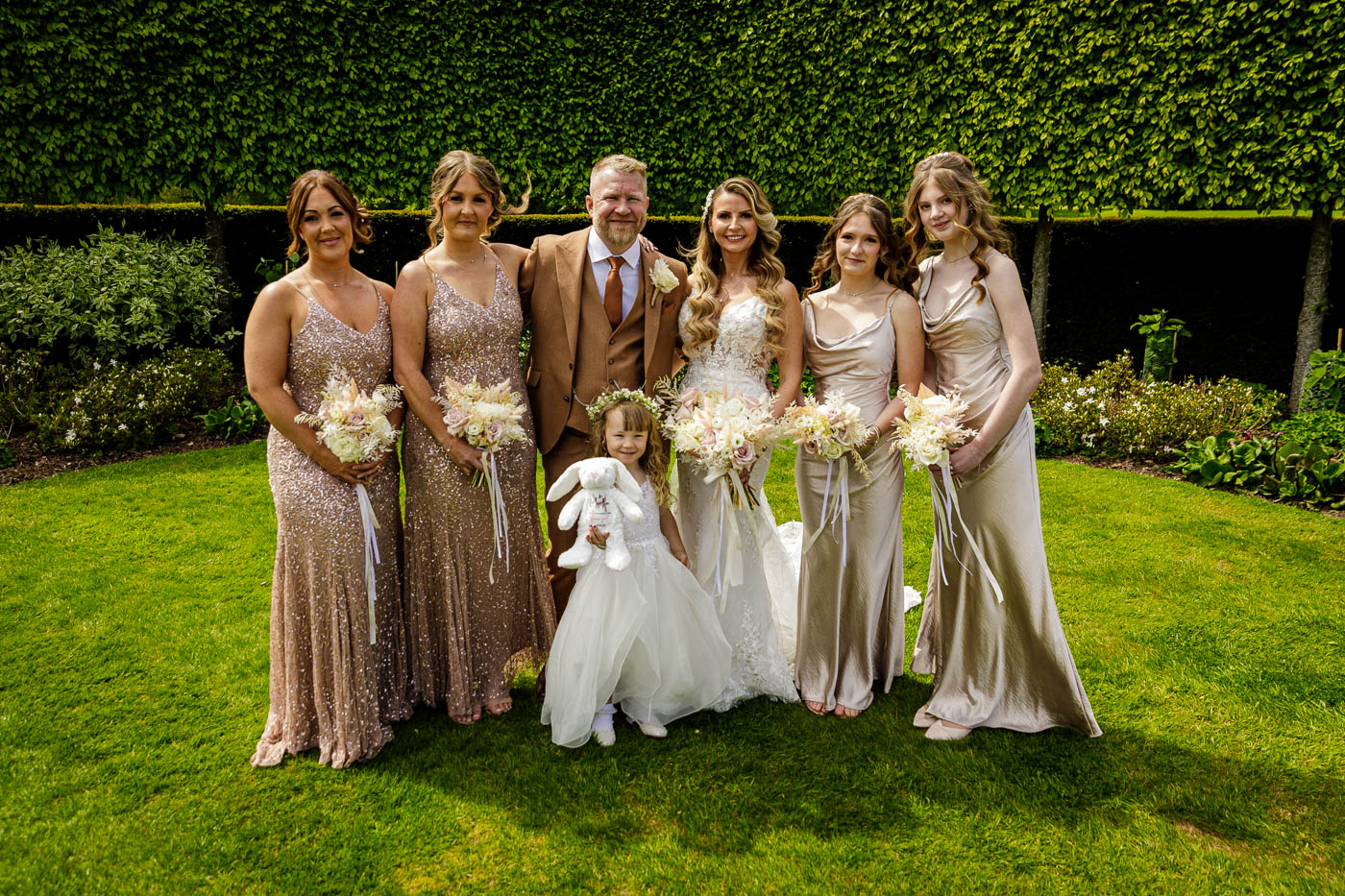 groom bride and bridemaids in gardens at merrydale