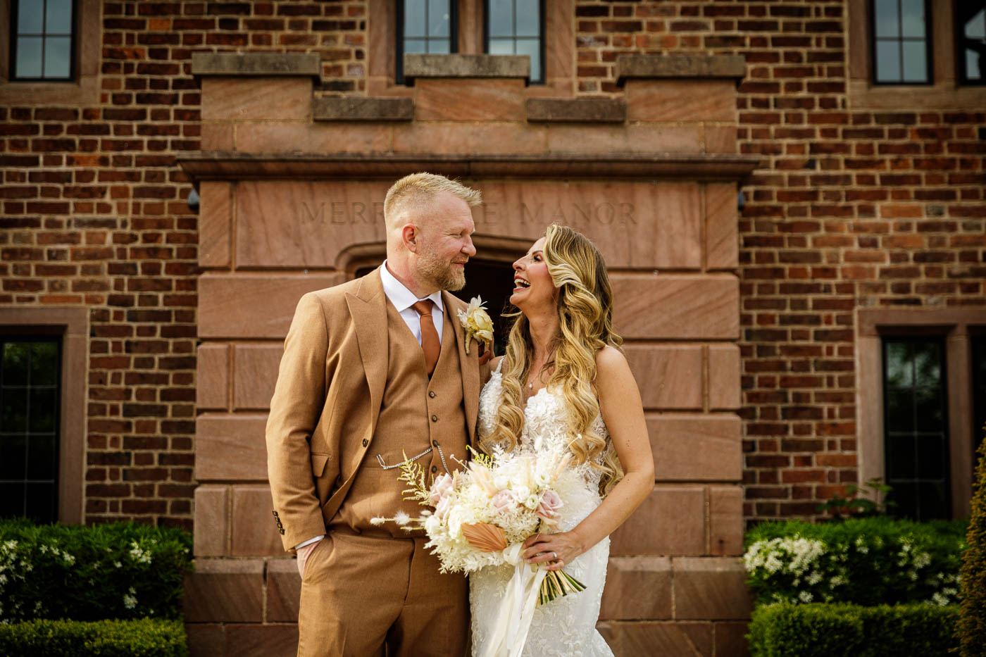 bride laughing with groom in front of merrydale manor