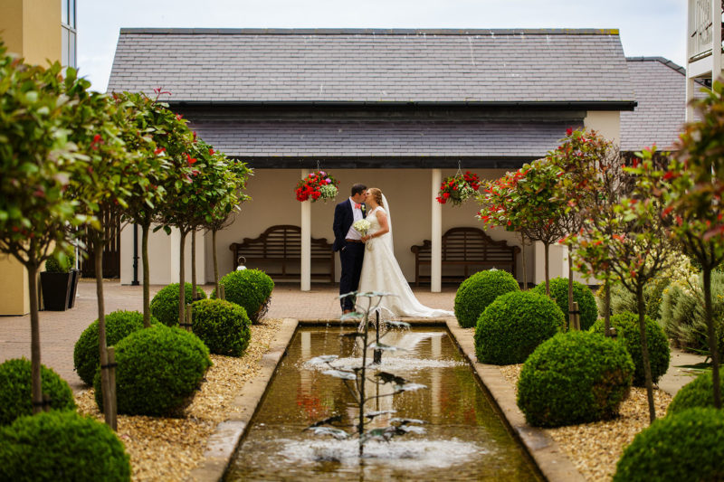 Bride and groom portrait near water feature