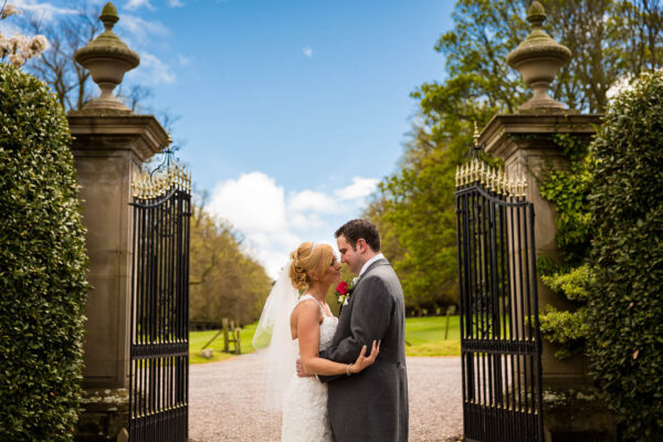 bride and groom at soughton hall gates