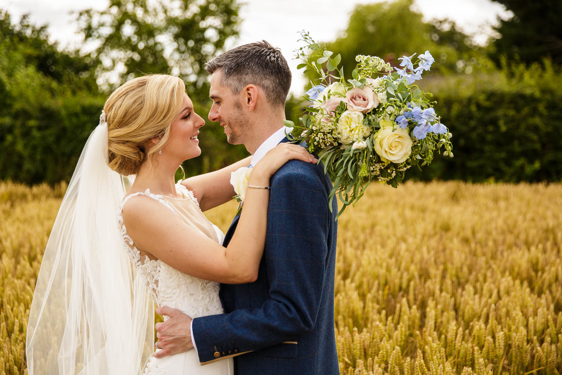 bride and groom portrait in wheat field at stock farm