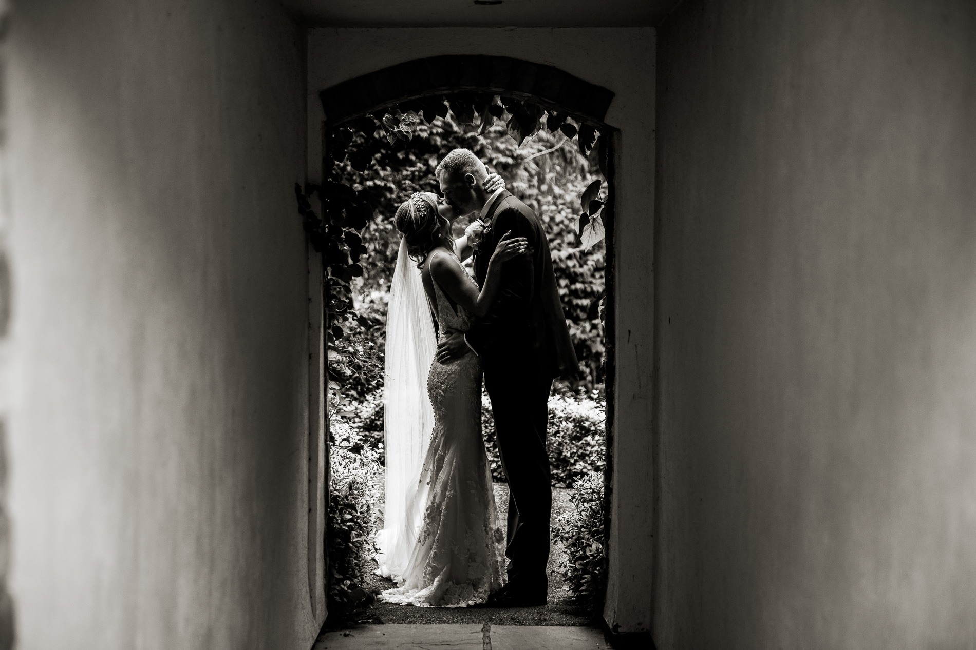 bride and groom kissing in doorway