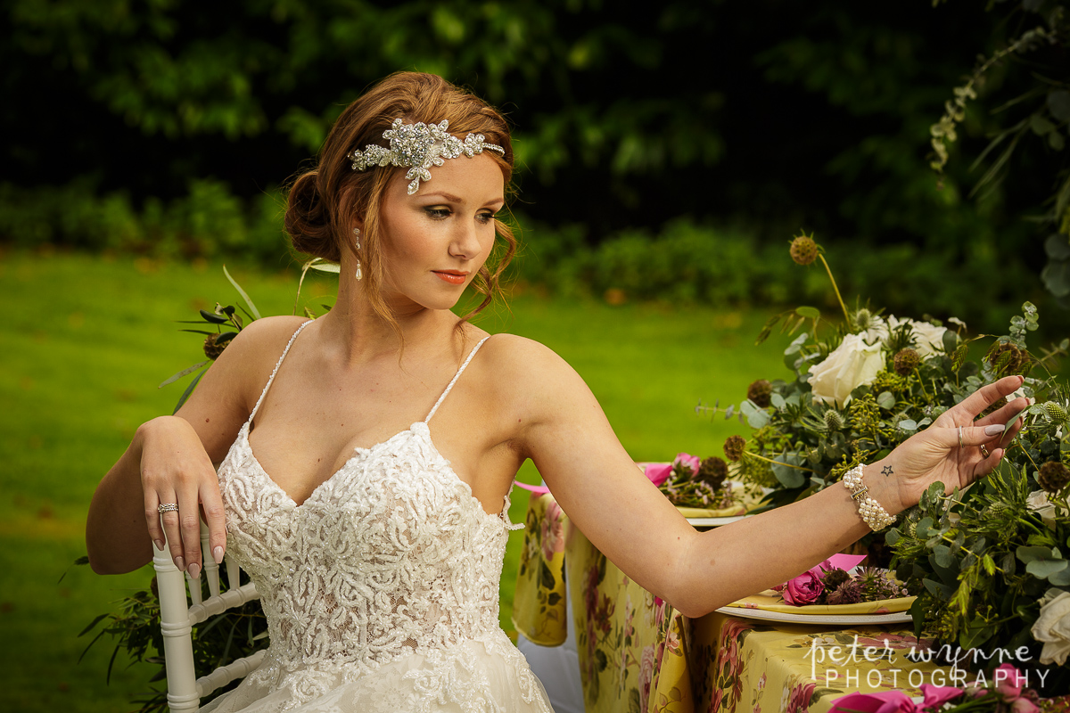 Bride sitting at outdoor table at Wrenbury Hall